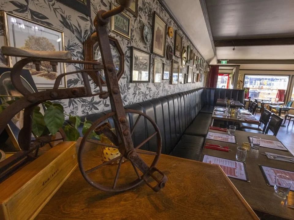 Le Charme French bistro interior — exposed brick walls, warm candlelight, and the signature red bar on Edmonton Trail, Calgary